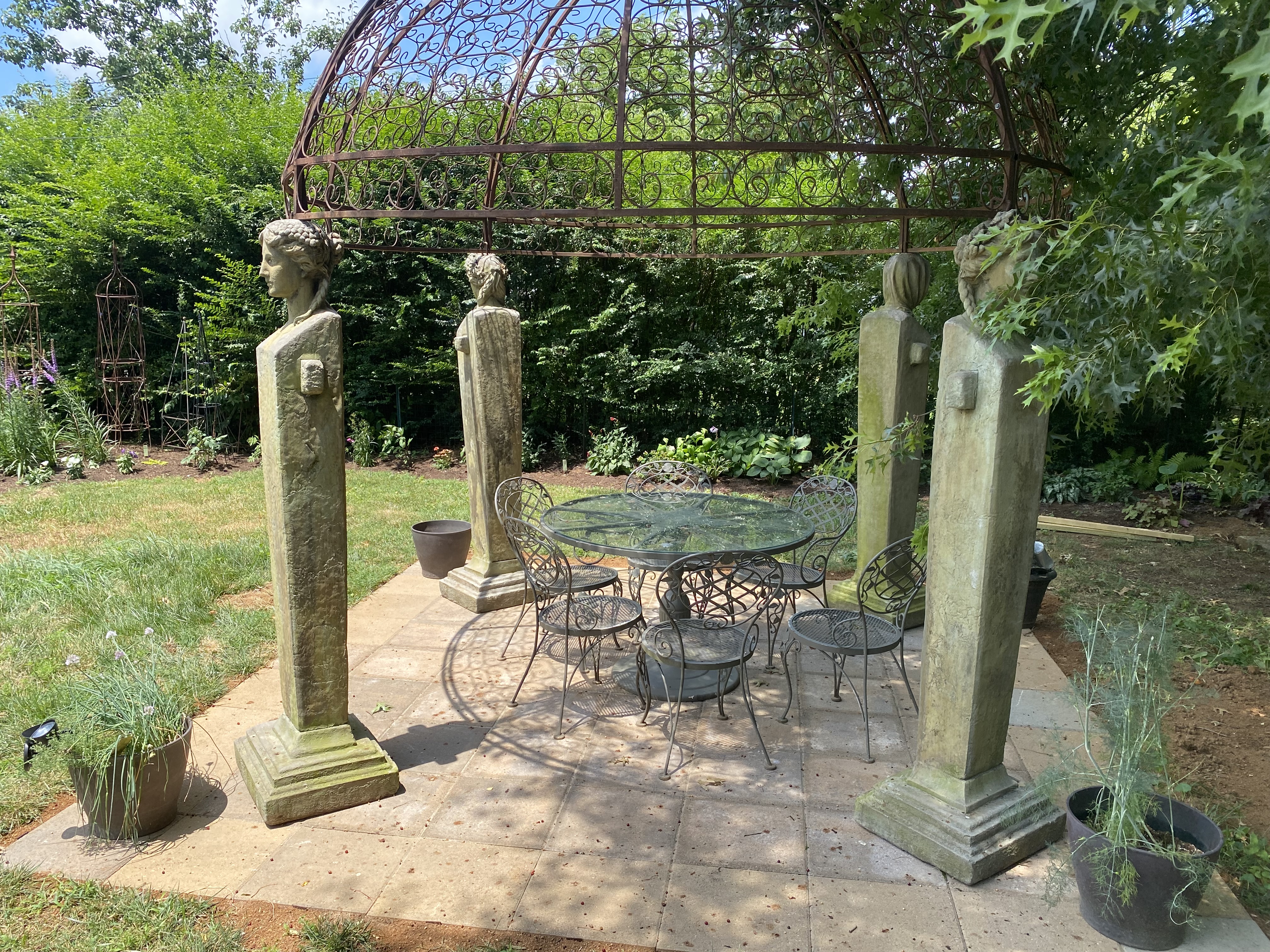 Garden patio with iron arbor and ornamental landscape beds